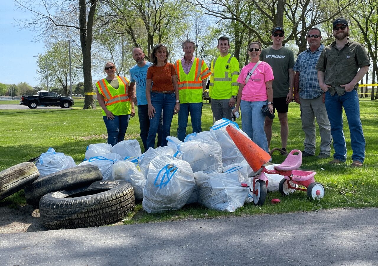 Barrett Midwest Division team celebrates Earth Day 2025 with a park cleanup, featuring tires and trash bags.